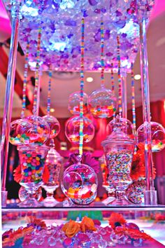 an assortment of candy and candies on display at a party or wedding reception with lights in the background