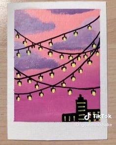 a painting with lights hanging from it's sides in front of a pink sky