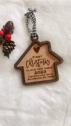 a wooden christmas ornament with a pine cone next to it and a red berry