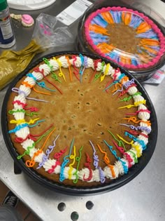 two cakes decorated with colorful icing and sprinkles on top of a table