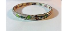 "Enamel on brass cloisonné' bangle bracelet with floral design. - pink, yellow, red, green, blue flowers and leaf on the outside and inside - off white background with shiny golden brass accents - measurements - 9 1/2\" outside circumference - 1/4\" wide - 2 3/4\" across - hallmark - none - condition - no issues. Clean with no noticeable chips or fading." Hand Painted Multicolor Bangle Jewelry, Multicolor Hand Painted Bangle Jewelry, Bohemian Enamel Bangle Bracelet, Bohemian Enamel Bangle Bracelets, Green Enamel Bangle, Multicolor Enamel Bangle Bracelets, Hand Painted Multicolor Bangle, Multicolor Hand Painted Bangle, Vintage Multicolor Enamel Bangle