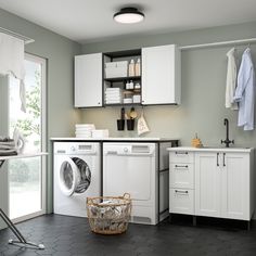 a washer and dryer sitting in a room next to a laundry basket on the floor