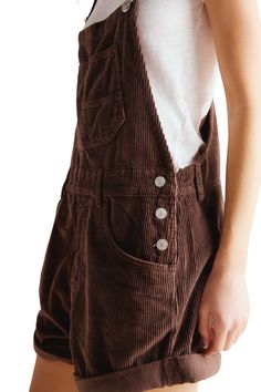 Ziggy Overalls Wash: Barnwood Dark brown curduroy short overalls. Bib-and-brace design with adjustable straps Front and side pockets Rolled hems Side tab button closure Relaxed fit Rise: 11.75" | Inseam: 5.5" (taken from size Small) 100% Cotton | Model is wearing a size Small Ziggy Overalls, Overall Shorts Outfit, Style Uniform, Baggy Shirts, Corduroy Dungarees, Farm Clothes, Outfits Baggy, Short Overalls, Clothing Design Sketches