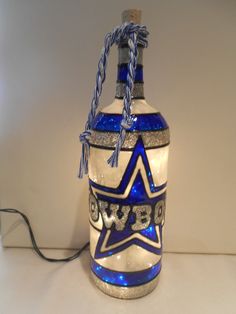 a blue and white glass bottle sitting on top of a table next to a charger