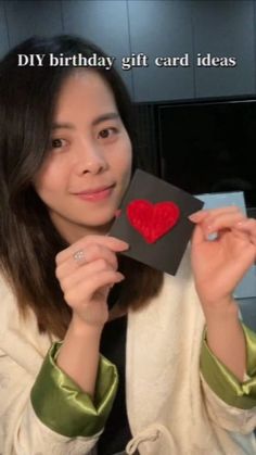 a woman holding up a card with a red heart on it that says diy birthday gift card ideas