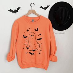 Listing: (1) Ghost with bats halloween Sweatshirt  -Cozy fleece crew to celebrate halloween and this spooky season!  Main Listing Photo: Orange sweatshirt.  Following Listing Photos... Ash, Black and Orange sweatshirts. All featuring white and black lettering for the design.  Branding:  Adult: Gildan / Unisex sizing  *Size chart available in photos section  Looking for more halloween themed items? Check out all our halloween items here: https://www.etsy.com/shop/TCCTN?ref=simple-shop-header-name Halloween Graphic Print Sweatshirt, Orange Crew Neck Halloween Sweatshirt, Spooky Oversized Halloween Sweatshirt, Oversized Spooky Halloween Sweatshirt, October Outfits, Halloween Orange, Halloween Items, Halloween Bats, Halloween Skeletons