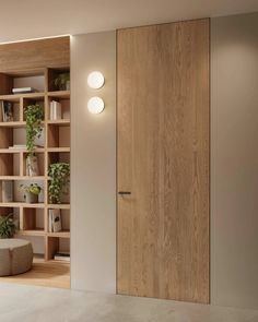 an empty room with wooden shelves and plants on the wall, along with a round ottoman