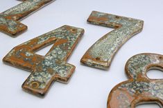 the numbers are made out of rusted metal and have been placed on a white surface