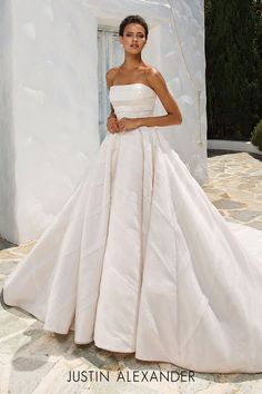 a woman in a white wedding dress posing for the camera