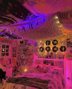 a bedroom decorated in pink, purple and black with lots of lights on the ceiling