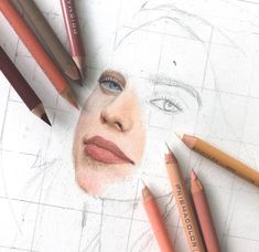 a pencil drawing of a woman's face surrounded by crayon pencils