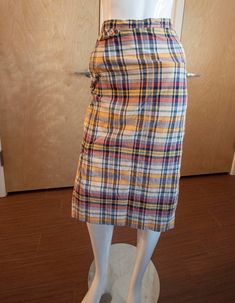 "Such a classic skirt from the mid-to-late '60s in a lightweight plaid cotton fabric! There is a pocket on the right hip on the seam; a fake flap pocket rests atop this area. On the left hip, there is a zipper and round wooden button closure. At the bottom of the skirt, there are vents on the left and right calves where the fabric is pleated, allowing ample room for walking since it's a midi skirt. Fabric: lightweight cotton Brand: Sirotto Sport Condition: good condition, no stains or holes, but could use a good steaming, there are tiny snags (only visible waaay up close) and the thread around the button started to unravel so I reinforced it Measurements: Waist: 12.5\" Hips: 17\" length: 27.5\"" Plaid Cotton Lined Skirt Bottoms, Plaid Pencil Skirt For Spring, Plaid Pencil Skirt For Spring Season, Cotton Lined Pencil Skirt For Fall, Fall Cotton Lined Pencil Skirt, Plaid Cotton Skirt For Work, Spring Plaid Pencil Skirt, Fall Cotton Knee-length Pencil Skirt, Retro Plaid Cotton Skirt