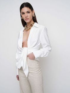 Find JACQUEMUS La Chemise Bahia Knotted Shirt on Editorialist. Plunge neckline. Long sleeves. Concealed front button closure. Button cuffs. Front knot detail. Draped front panels. Asymmetrical. Model is wearing a size34 Luxury White Button-up Blouse, Designer White Button-up Blouse, Luxury White Party Blouse, Elegant Evening Shirt For Summer, Draped Shirt, Knotted Shirt, Plunge Neckline, Asymmetrical Skirt, Asymmetrical Tops