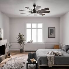 a bed room with a neatly made bed and a fan on the wall above it