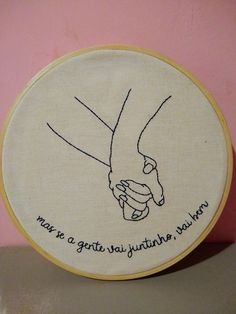 a close up of a embroidery on a wall with a hand holding a baby's foot