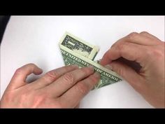 someone is cutting out the dollar bill with scissors