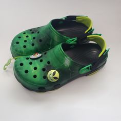 Elevate Your Casual Shoe Game With These Crocs X Ron English Area 54 Clogs. The Slip-On Design With A Round Toe Shape Provides Comfort And Convenience For All-Day Wear. The Green Blended Fabric Upper Material Is Accented With Jibbitz Details And A Solid Pattern. Green Slip-on Synthetic Clogs, Green Closed Toe Synthetic Clogs, Green Synthetic Clogs For Outdoor, Green Synthetic Slip-on Clogs, Green Synthetic Closed Toe Clogs, Green Synthetic Outdoor Clogs, Green Non-slip Closed Toe Clogs, Green Synthetic Clogs With Round Toe, Green Round Toe Sandals For Streetwear