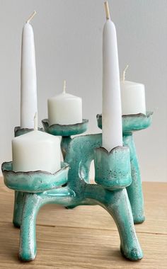 three candles sitting on top of a wooden table