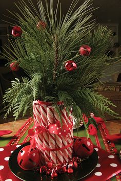 a christmas centerpiece with ladybug decorations and greenery in a polka dot vase