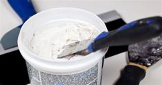 a paint bucket and brush on a table