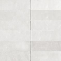 a white tile wall with vertical lines on it