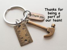 a metal keychain with a measuring tape and a hammer on it that says thanks for being a part of our team