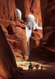 two camels are standing in front of some buildings on the side of a mountain