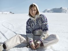 a woman sitting in the snow with her legs crossed