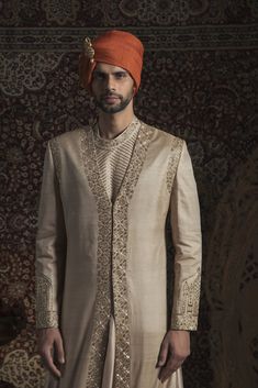 Editor's Note Golden Matka Silk Sherwani With Arabic Theme Fabric: Tussor Color: Beige Embroidery Details: Kat Dana And Sequin Care: Dry Clean Only About the Designer Rachit Khanna who had followed his passion for fashion sets the benchmark in the designs through his versatility & craftsmanship. The technique & embellishment on each piece is beyond & takes a great level of effort to put every client's dream into reality & visualizing the amount of comfort & glam quotient for each & surprisingly. Rachit Khanna, Beige Embroidery, Embroidered Sherwani, Indian Groom Wear, Indian Groom, Groom Wear, Embroidered Neckline, Indian Fashion Designers, Pernia Pop Up Shop