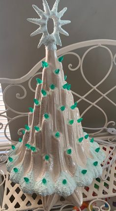 a glass christmas tree with green and white decorations