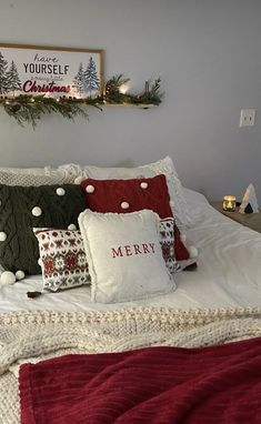 a bed topped with lots of pillows covered in christmas decorations