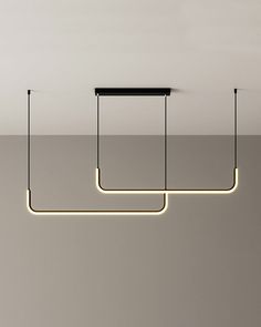 three rectangular lights suspended from the ceiling in a room with grey walls and flooring