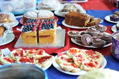 a table topped with lots of cakes and desserts