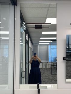 a woman taking a selfie in front of a mirror