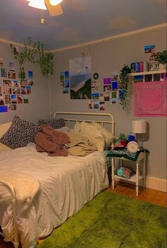 a bedroom with a white bed, green rug and pictures on the wall above it