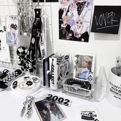 an assortment of items displayed on a table with tags and pictures hanging from the wall