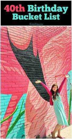 a woman standing in front of a pink flamingo painted on the side of a building