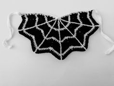 a black and white photo of a spider web ornament made out of yarn