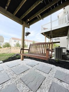 a wooden bench sitting on top of a stone patio