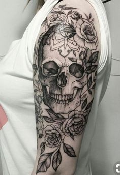 a woman with a skull and roses tattoo on her arm