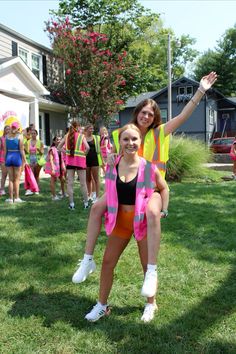 two girls in neon vests and white shoes are posing for the camera with their arms outstretched