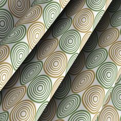 a close up view of a green and gold patterned curtain with circles in the center