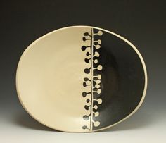 a black and white plate with an abstract design on the side, against a gray background