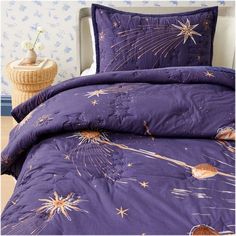 a purple comforter with fireworks and stars on it