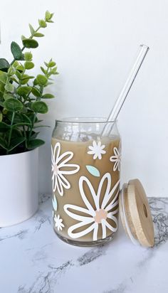 a glass jar filled with liquid next to a potted plant on a marble counter