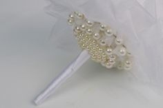 a white bridal brush with pearls on it's side and a plastic bag in the background