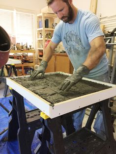 a man is working with cement on a table