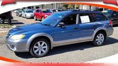 a silver suv is parked in a lot with other cars behind it and an orange ribbon around the front window