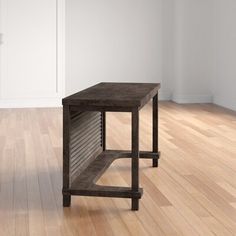 a wooden table sitting on top of a hard wood floor next to a white wall