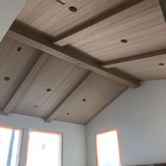 an empty room with two windows and wooden beams on the ceiling is pictured in this image